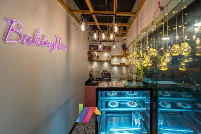 Restaurant counter beside a plant-covered feature wall and pendant lights.