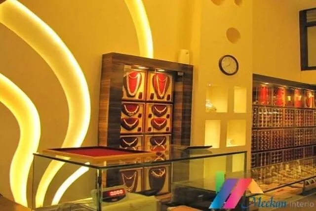 Jewellery display counters beneath curved gold ceiling lights.