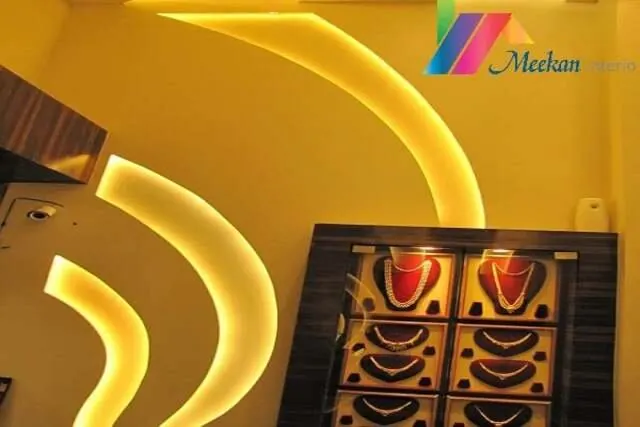 Jewellery cabinets beneath curved yellow ceiling lights.