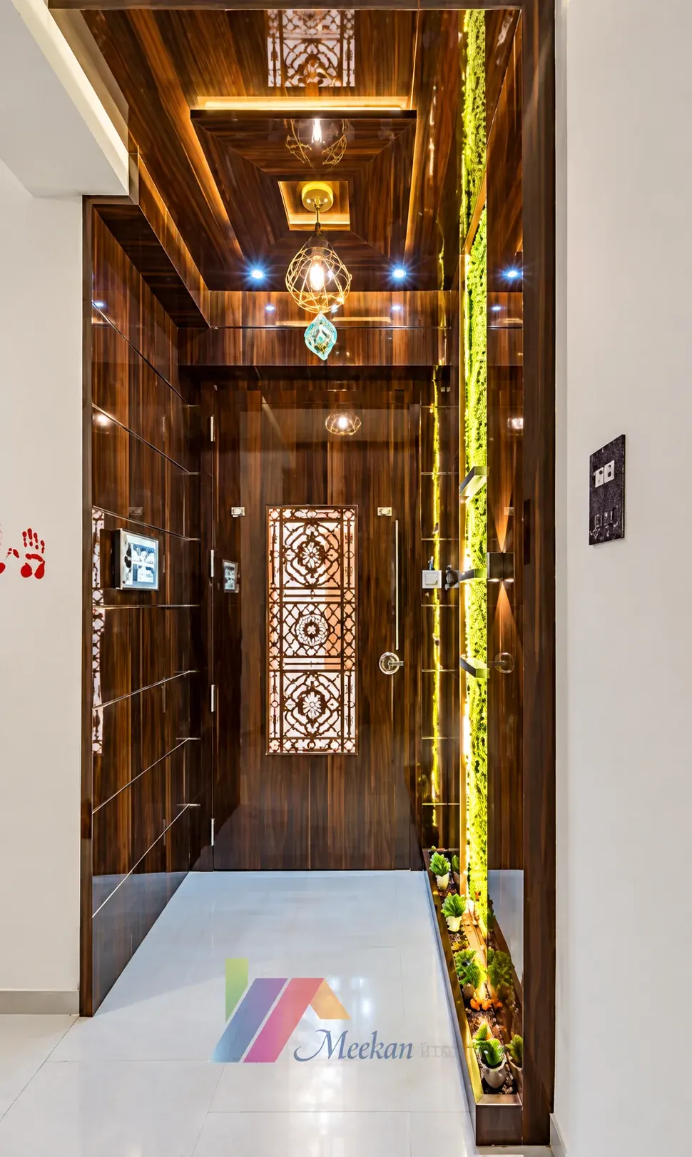 Timber entrance corridor with illuminated ceiling details and a carved metal gate.